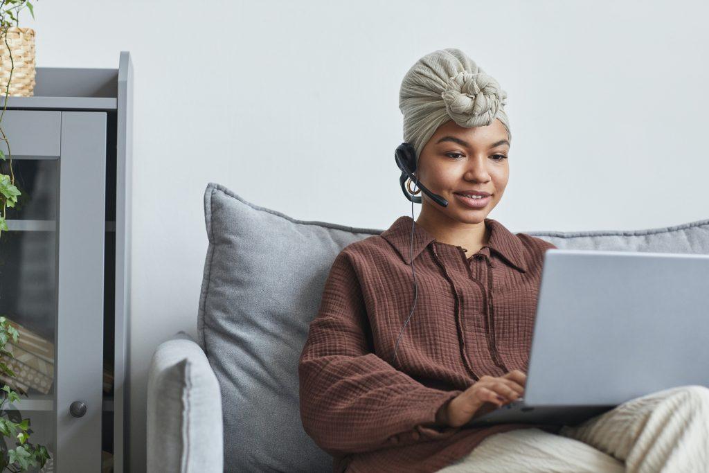 Woman on laptop while using headset